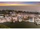 Dusk aerial view of a waterfront home with pool and boat dock in a coastal setting at 4 Winslow Pl, Longboat Key, FL 34228
