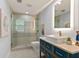Bathroom featuring tiled glass enclosed shower, granite vanity and lighted mirror with decor at 4 Winslow Pl, Longboat Key, FL 34228