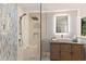 Bathroom featuring glass enclosed shower with mosaic tile, stone floors, and wood vanity with modern sink at 4 Winslow Pl, Longboat Key, FL 34228