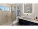 Bathroom with glass shower, vessel sink on vanity with framed art and window overlooking exterior at 4 Winslow Pl, Longboat Key, FL 34228