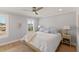 This bedroom features a ceiling fan, two windows with white shutters and wood flooring at 4 Winslow Pl, Longboat Key, FL 34228