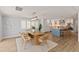 Dining room with wood table and chairs, modern lighting, and open access to the kitchen at 4 Winslow Pl, Longboat Key, FL 34228