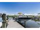 Boat on a lift at a wooden dock on a sunny day with blue skies and calm water at 4 Winslow Pl, Longboat Key, FL 34228
