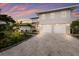 Elegant two-story home featuring a spacious three-car garage, complemented by lush landscaping and a paved driveway at 4 Winslow Pl, Longboat Key, FL 34228