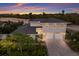 Stunning two-story home with a three-car garage, lush landscaping, and a beautiful sunset backdrop near the waterfront at 4 Winslow Pl, Longboat Key, FL 34228