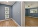 Hallway with three framed windows showing the outdoor view and wood flooring leading into a room at 4 Winslow Pl, Longboat Key, FL 34228
