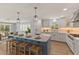 Bright kitchen with island, pendant lighting, stainless appliances, and views into a light-filled dining area at 4 Winslow Pl, Longboat Key, FL 34228