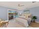 Bedroom suite with king bed, soft rug, neutral decor, and sliding glass door to patio and pool views at 4 Winslow Pl, Longboat Key, FL 34228