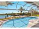 Backyard pool area with a dock, screened enclosure, and clear blue water views at 4 Winslow Pl, Longboat Key, FL 34228