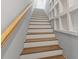 Looking up the gray and white wood staircase with a wooden handrail and white bookshelf cubbies at 4 Winslow Pl, Longboat Key, FL 34228