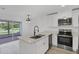 Bright kitchen area featuring stone countertops, stainless steel appliances, and an adjacent dining area at 4131 Oakhurst W Cir # 3133, Sarasota, FL 34233