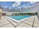 Community pool with a screened enclosure, deck chairs and ample space for gatherings at 4131 Oakhurst W Cir # 3133, Sarasota, FL 34233