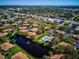 Community aerial featuring a swimming pool, and a serene pond surrounded by residential buildings and greenery at 4165 66Th Street W Cir # H, Bradenton, FL 34209