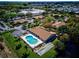 Aerial view of community pool and shuffleboard courts surrounded by lush greenery and residential buildings at 4165 66Th Street W Cir # H, Bradenton, FL 34209