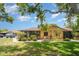 Charming single-story home featuring a screened patio with lush landscaping and mature trees on a sunny day at 4165 66Th Street W Cir # H, Bradenton, FL 34209