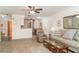 Living room with tile floors, neutral furniture, ceiling fans, and open access to the kitchen and dining area at 4165 66Th Street W Cir # H, Bradenton, FL 34209