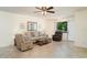 Inviting living room with tiled floors, neutral furniture, a ceiling fan, and natural light from a window at 4165 66Th Street W Cir # H, Bradenton, FL 34209