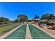 Well-maintained shuffleboard courts with clear markings, surrounded by benches and lush landscaping at 4165 66Th Street W Cir # H, Bradenton, FL 34209