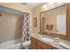 Bathroom featuring a tub-shower, granite vanity, large mirror, and neutral color palette at 4637 Willow Wood Cir # 44, Sarasota, FL 34241