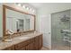 Modern main bathroom with granite countertop, wood vanity, framed mirror, closet and neutral paint scheme at 4637 Willow Wood Cir # 44, Sarasota, FL 34241