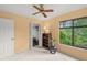 Comfortable, peach bedroom with closet, a fan, and large window view to the beautiful outdoor view at 4637 Willow Wood Cir # 44, Sarasota, FL 34241