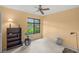 Neutral bedroom with a ceiling fan, large window with green view, and functional furniture at 4637 Willow Wood Cir # 44, Sarasota, FL 34241