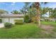 Well-maintained home exterior with lush lawn and tropical landscaping with palm trees at 4637 Willow Wood Cir # 44, Sarasota, FL 34241