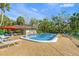 Community pool area featuring lounge chairs, tables, and a poolside building under a clear sky at 4637 Willow Wood Cir # 44, Sarasota, FL 34241