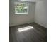 Cozy bedroom with wood-look flooring, bright window, and fresh neutral paint at 4740 Garcia Ave, Sarasota, FL 34233