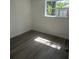 Cozy bedroom with wood-look flooring, bright window, and fresh neutral paint at 4740 Garcia Ave, Sarasota, FL 34233