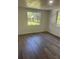 Cozy bedroom with wood-look flooring, bright windows, and fresh neutral paint at 4740 Garcia Ave, Sarasota, FL 34233