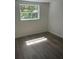 Cozy bedroom with wood-look flooring, bright window, and fresh neutral paint at 4740 Garcia Ave, Sarasota, FL 34233