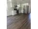 Bright kitchen features white cabinets, stainless steel appliances, and wood-look flooring at 4740 Garcia Ave, Sarasota, FL 34233