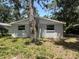 Exterior rear of home with white painted windows and central air unit surrounded by a tree at 4740 Garcia Ave, Sarasota, FL 34233