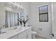 Well-lit bathroom with a single vanity, large mirror, and minimalist decor at 4925 Coastal Days Ln, Bradenton, FL 34211