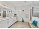 Bright bathroom with double vanity, decorative mirror and tile, and separate glass-enclosed shower at 4925 Coastal Days Ln, Bradenton, FL 34211