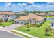 Stunning exterior view of a single-Gathering home featuring a tile roof, three-car garage and well-manicured landscaping at 4925 Coastal Days Ln, Bradenton, FL 34211
