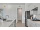 Bright kitchen features stainless steel appliances, white cabinets, a breakfast bar, and modern pendant lighting at 4925 Coastal Days Ln, Bradenton, FL 34211