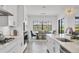 Kitchen features white cabinets, stainless steel appliances, quartz countertops, and modern pendant lighting at 4925 Coastal Days Ln, Bradenton, FL 34211