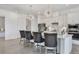 Kitchen features stainless steel appliances, a large island with barstool seating, and modern lighting fixtures at 4925 Coastal Days Ln, Bradenton, FL 34211