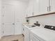 Bright laundry room with front-load washer and dryer, overhead cabinets, and ample counter space at 4925 Coastal Days Ln, Bradenton, FL 34211