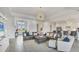 Spacious living room boasts modern lighting, tiled floors, a large brown leather sofa, and tasteful decor at 4925 Coastal Days Ln, Bradenton, FL 34211