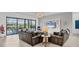 Bright living room featuring two leather couches, modern lighting, and sliding glass doors leading to the backyard at 4925 Coastal Days Ln, Bradenton, FL 34211