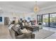 Spacious living room with modern decor, a large sectional sofa, and ample natural light at 4925 Coastal Days Ln, Bradenton, FL 34211