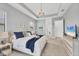 Beautiful main bedroom with tray ceilings, soft lighting, a bed with blue accents, and a dresser with television at 4925 Coastal Days Ln, Bradenton, FL 34211