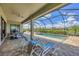 Relaxing screened patio featuring lounge chairs, ceiling fan, and a beautiful view of the sparkling pool and landscaping at 4925 Coastal Days Ln, Bradenton, FL 34211