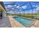 A beautiful, sparkling screened pool with brick patio, well maintained landscaping, and relaxing lounge chairs at 4925 Coastal Days Ln, Bradenton, FL 34211