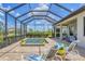 Screened in pool with spa and lounge chairs, surrounded by lush landscaping, and featuring a covered patio at 4925 Coastal Days Ln, Bradenton, FL 34211