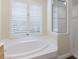 Bathroom featuring soaking tub, shower, and plantation shutters at 4998 Cedar Oak Way, Sarasota, FL 34233