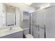 Bright bathroom features a vanity, toilet, frosted glass shower, and storage cabinet at 4998 Cedar Oak Way, Sarasota, FL 34233